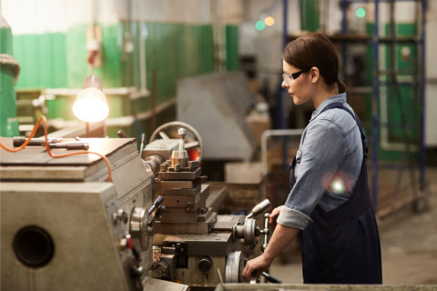 Vrouw werkt aan draaibank in atelier
